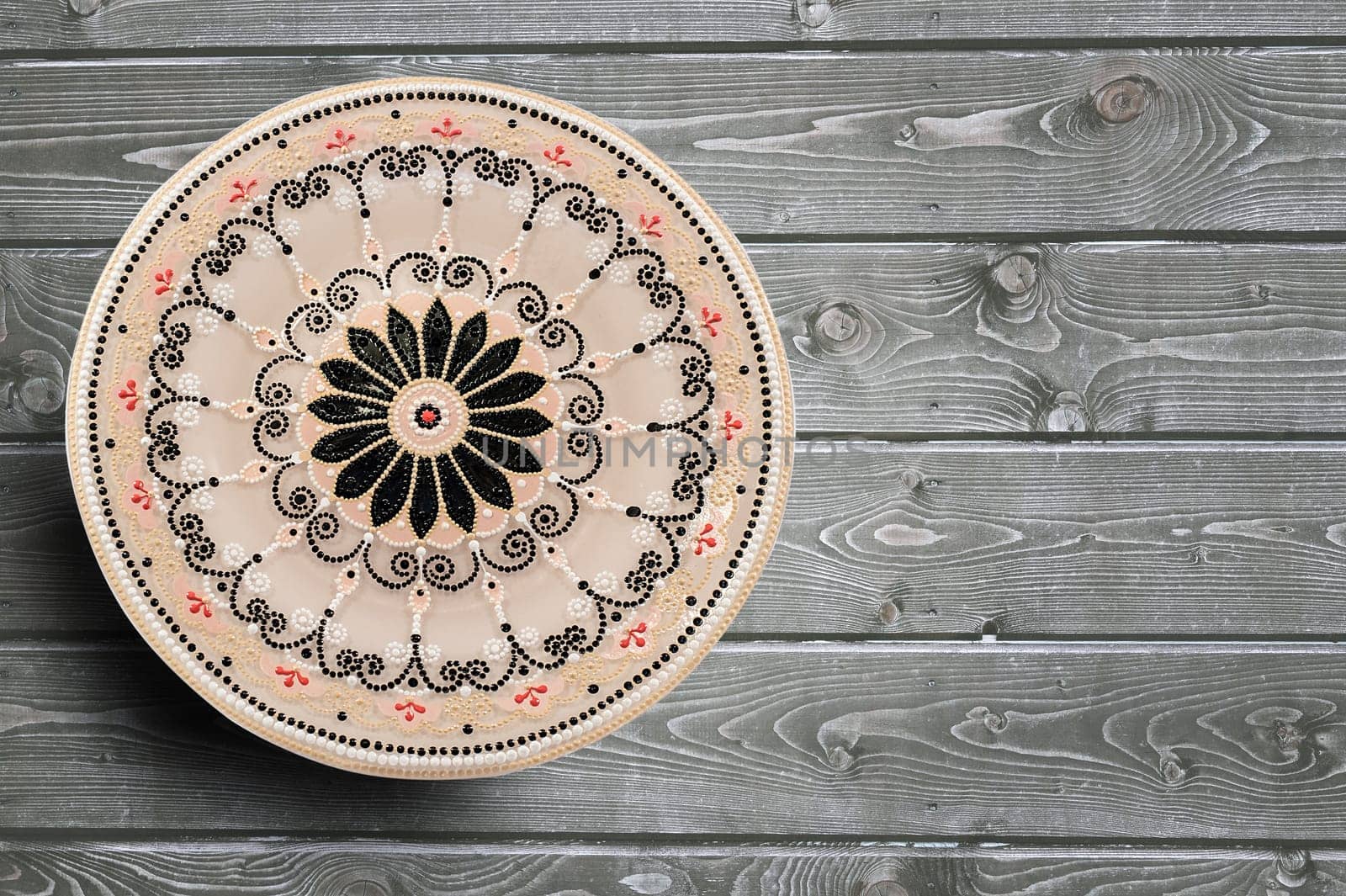 Decorative ceramic dish painted with hands. Art, handmade. Pattern mandala