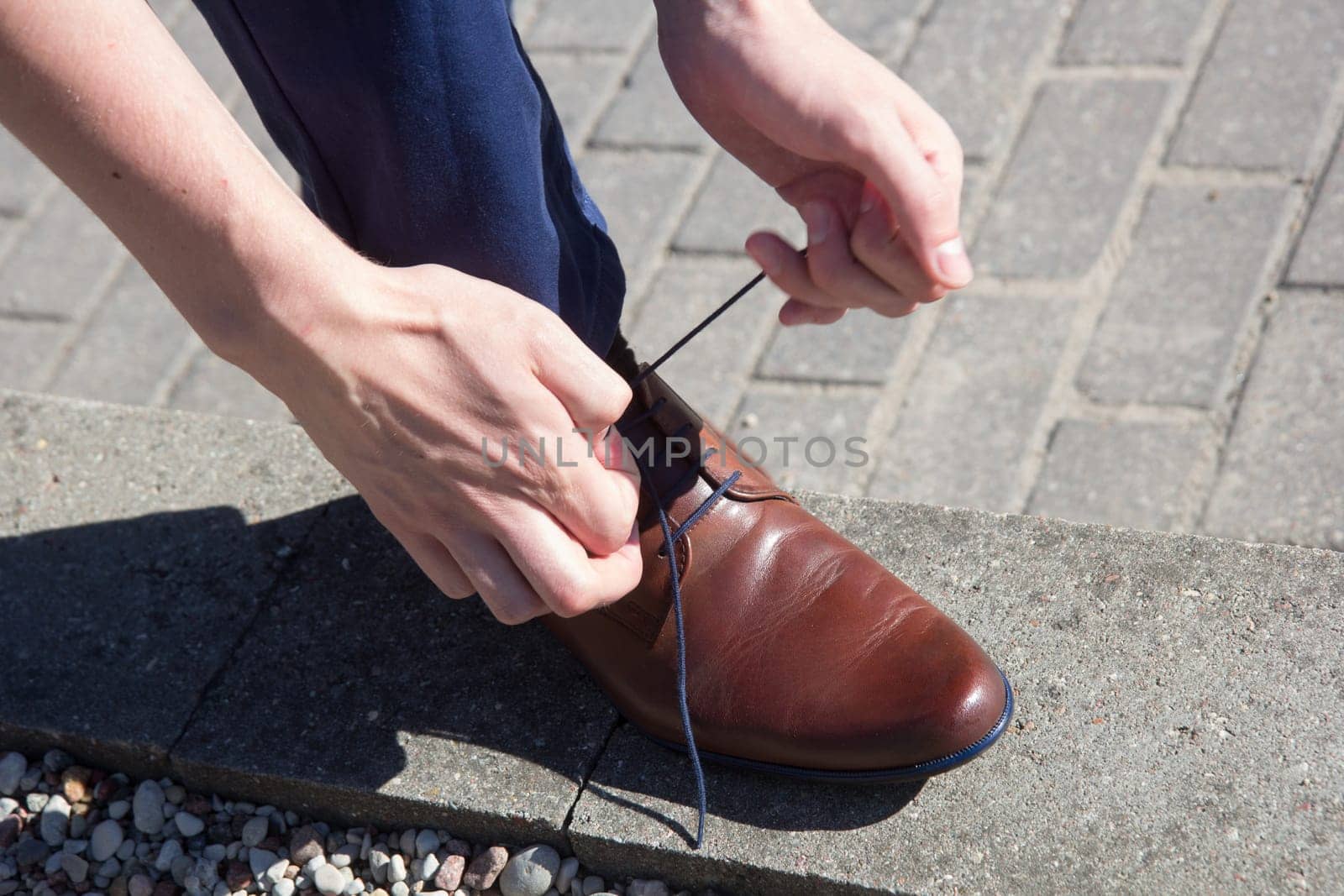Man tying shoes laces on the street