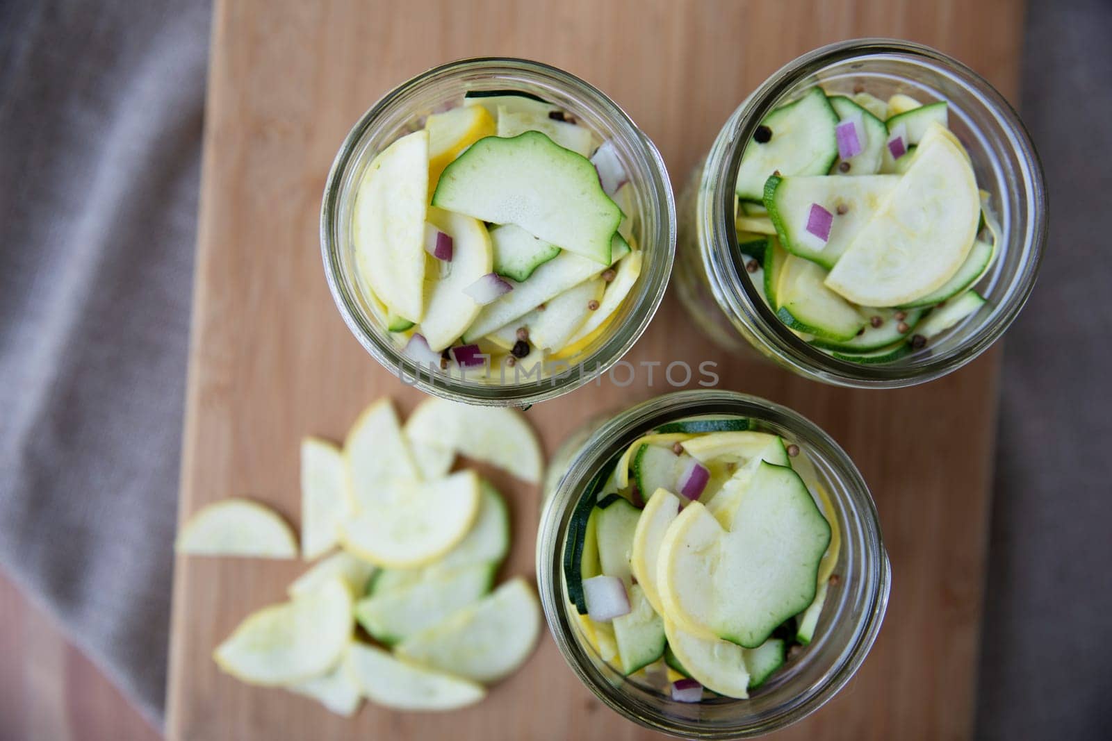 Fresh sliced zucchini and yellow squash in canning jars for pickling.