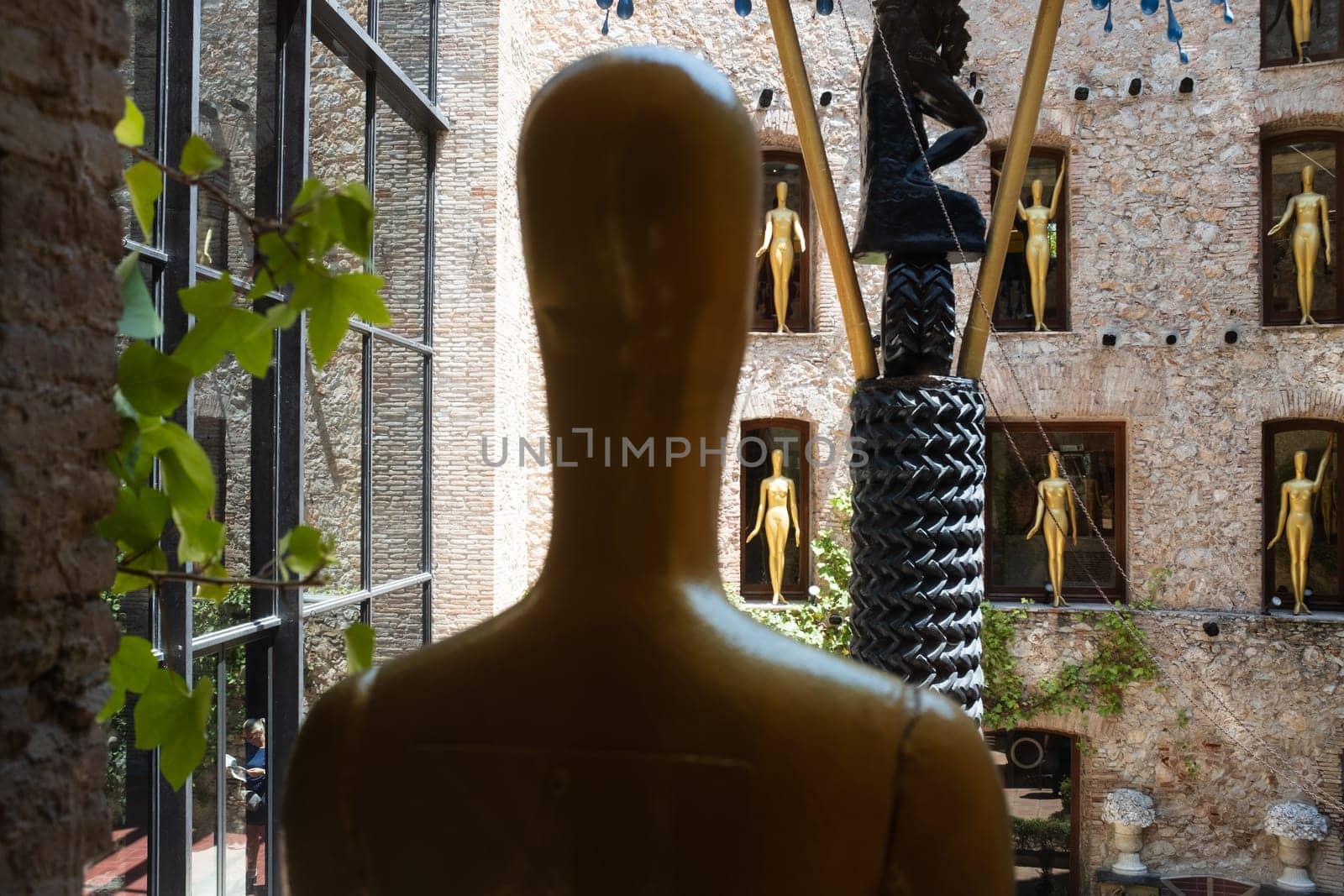Salvador Dalì's Theatre Museum, Figueres, Spain: blurred close up of golden statue and partial view of the open courtyard, in background.