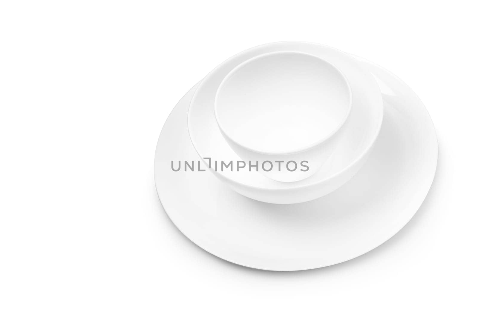 Set of white dishes on table on light background. With clippig path