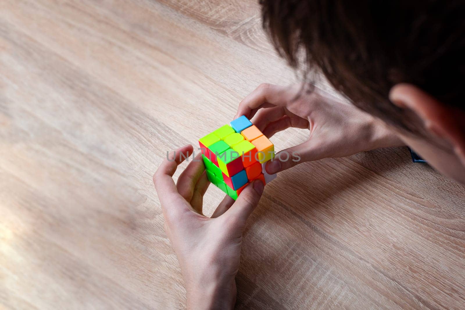 CHISINAU, MOLDOVA - June 27, 2019: Boy holding Rubik's cube and playing with it. Rubik's cube in child's hands, closeup.