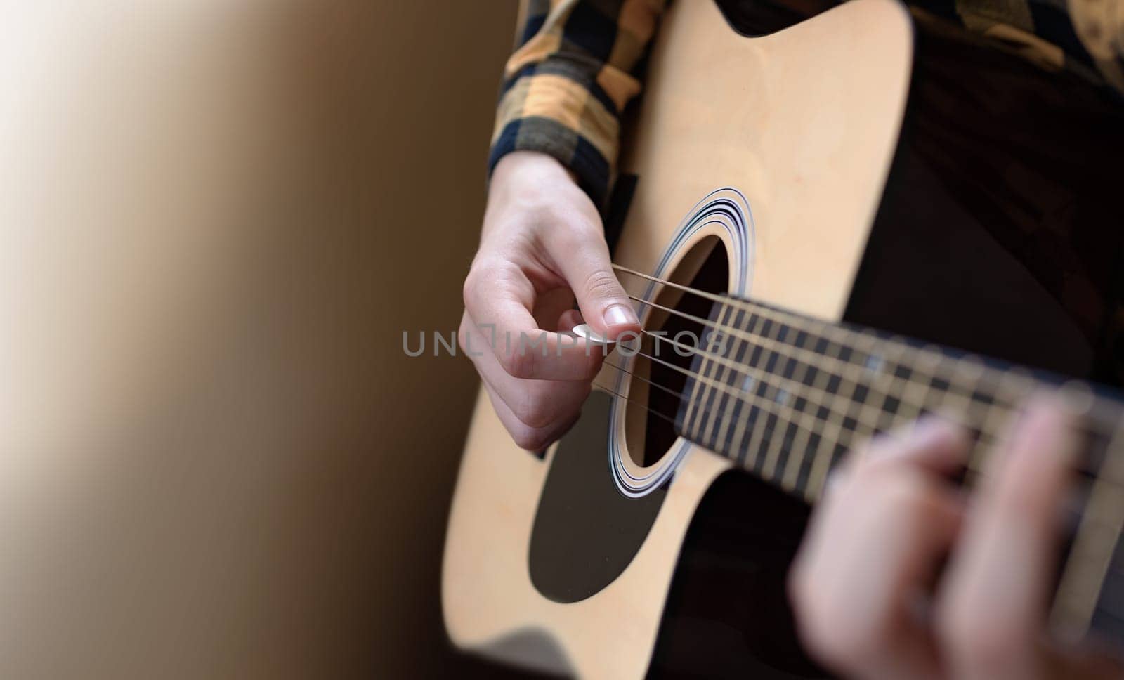 The young man tuning the electric guitar. Closeup