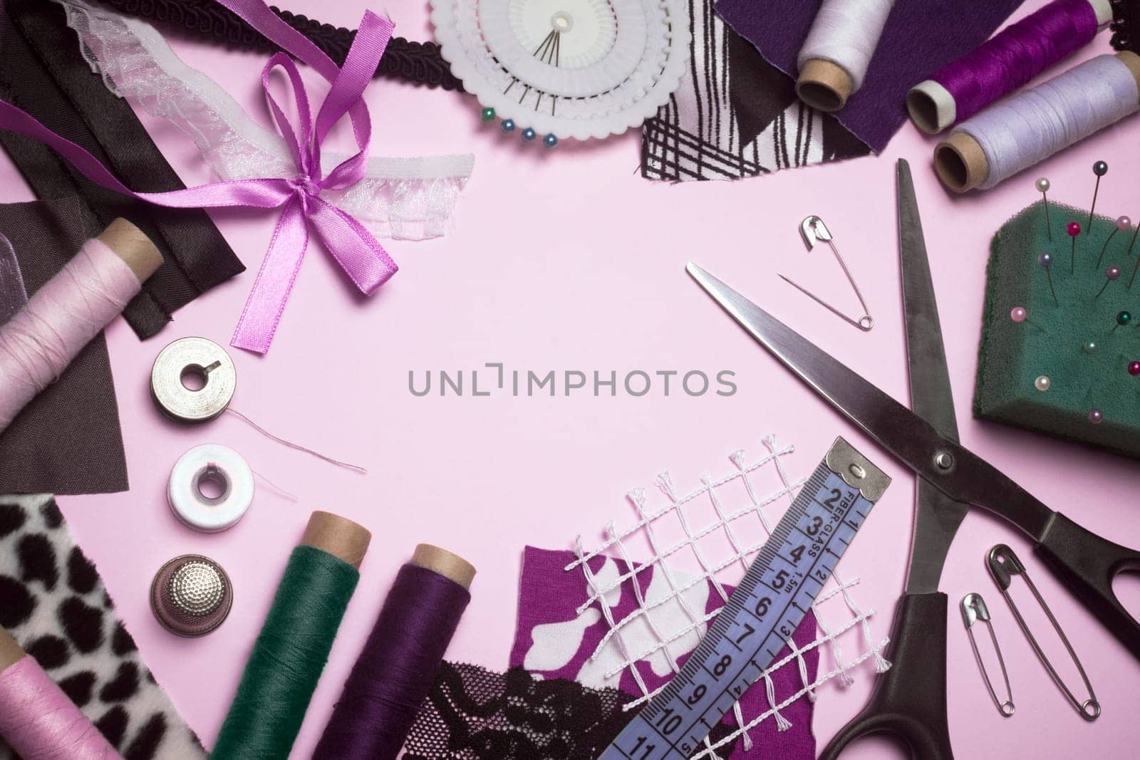 Sewing supplies, group of objects for sewing on pink background.