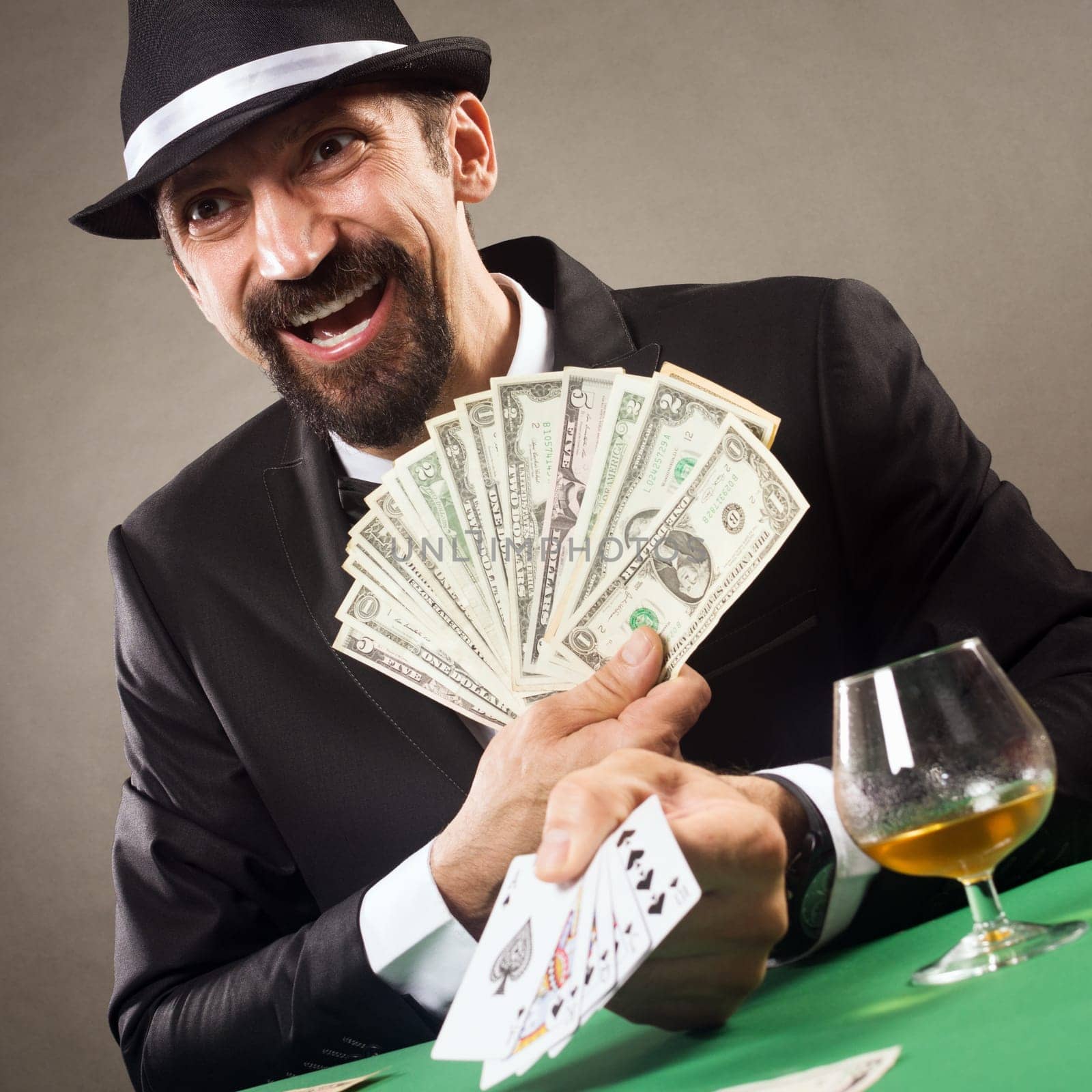 The happy gambler is lucky in poker card and winning cash prize in casino.