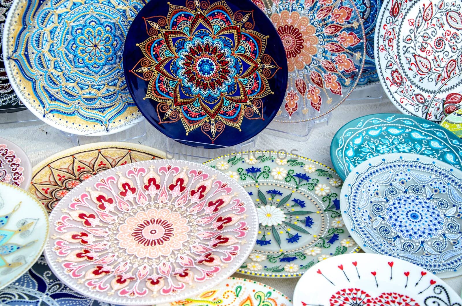 Ceramic plates, hand-painted with a dot pattern, are on the counter at the festive fair