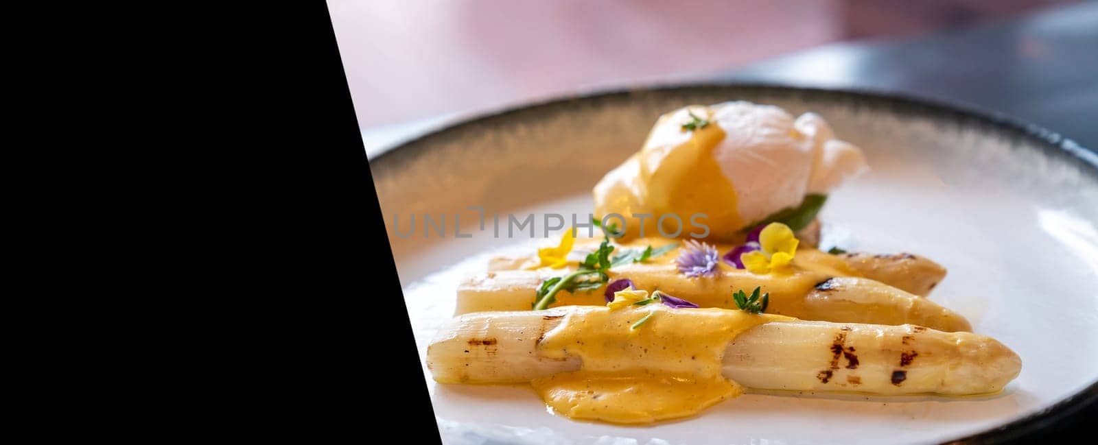 Gourmet grilled white asparagus with poached egg serve with hollandaise savory sauce decorate with edible colorful flowers designed for using as web banner