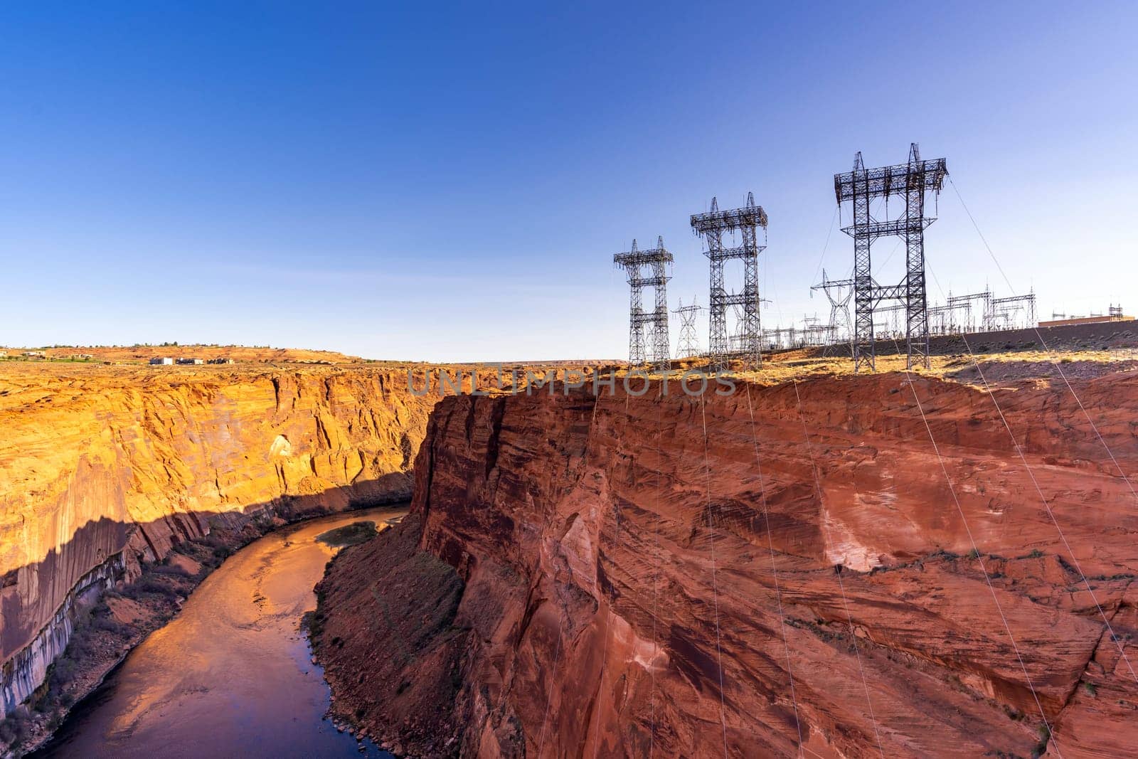 Power plant house and power line over Electricity generating dam with river colorado in Page Arizona USA