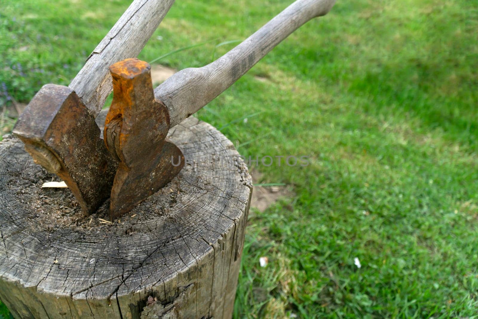 Two old rusted Axes on a wooden block
