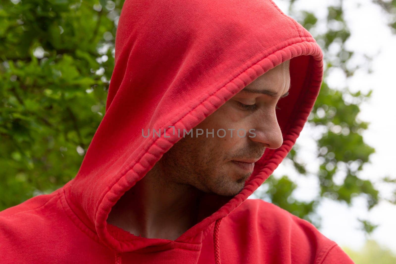 Portrait from young man with red hoodie looking real serious