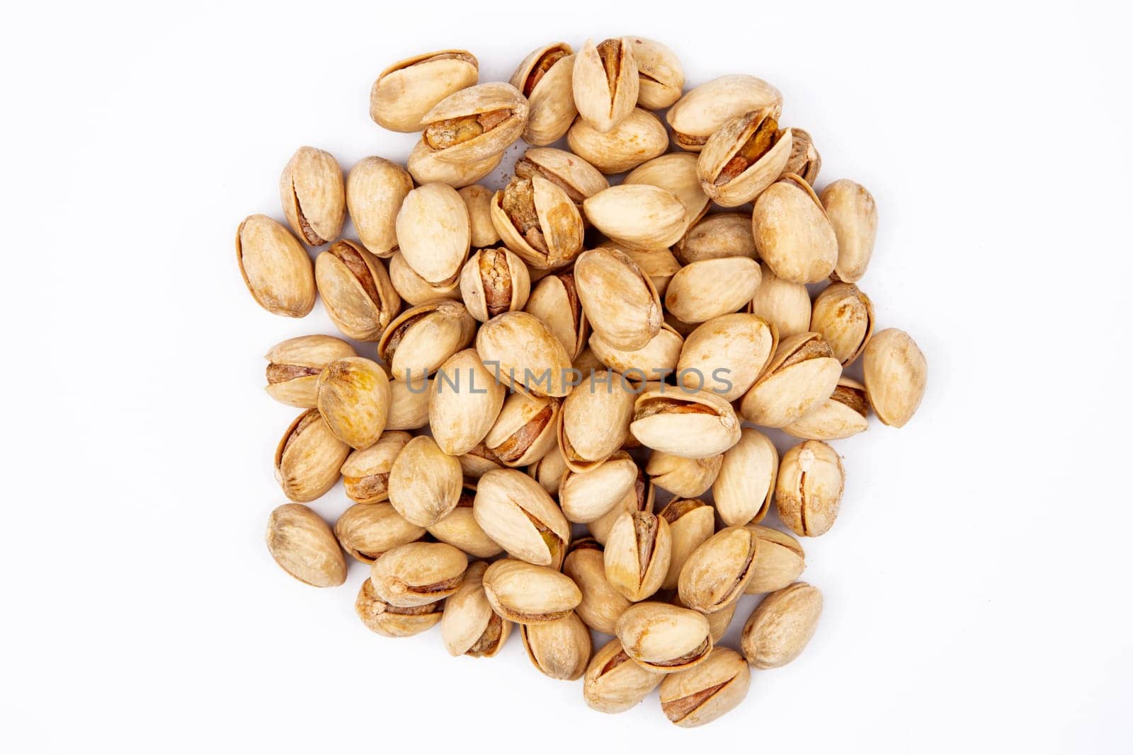 Heap of unpeeled Pistachios on white background