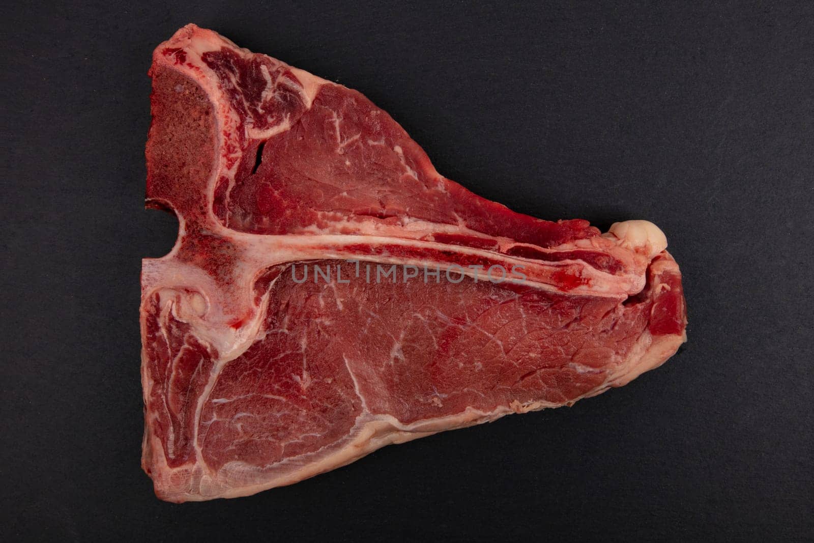 Raw T Bone Steak isolated on dark background