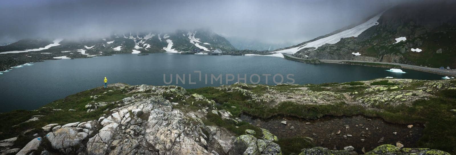 Young admiring the natural beauty of a glaciar lake in Swiss Alps - Panoramic image