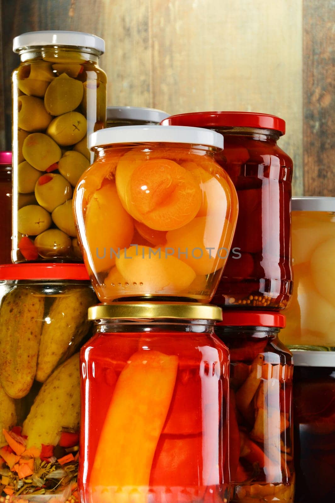 Jars with pickled vegetables, fruity compotes and jams in cellar. Preserved food