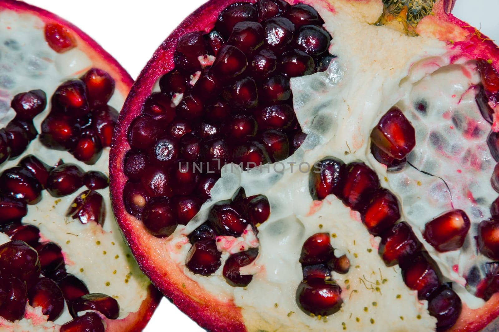 Broken in half, the fruit of a pomegranate and white background.