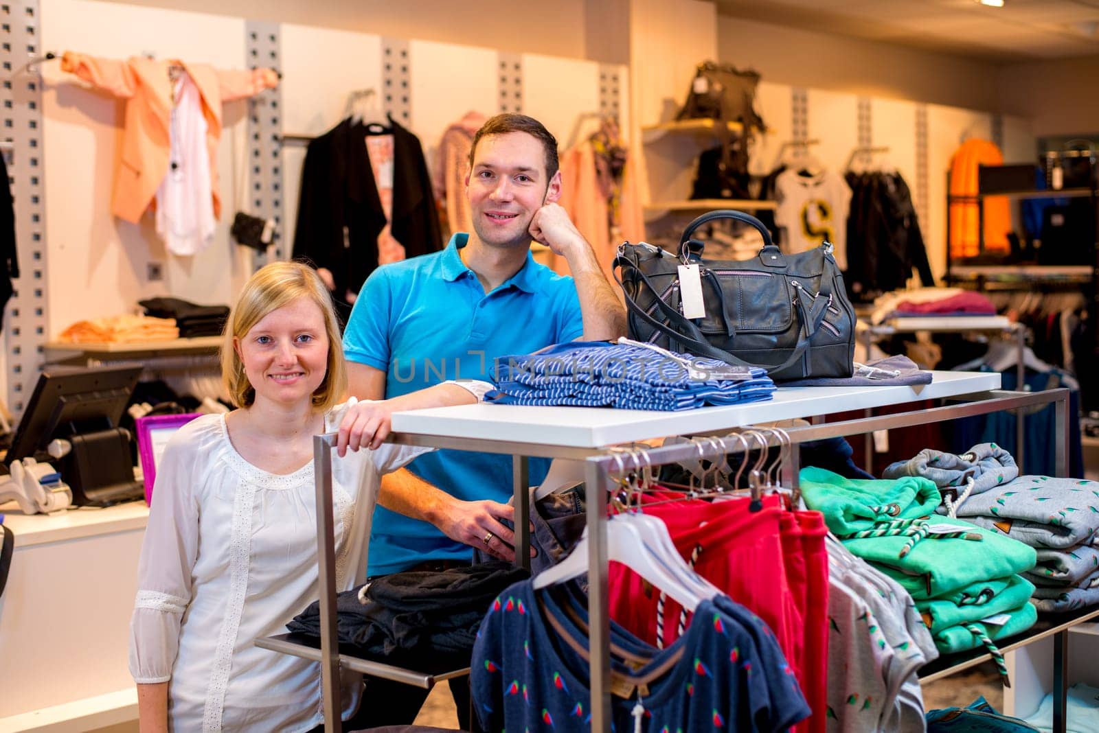 young couple in the clothes shop looking in to the camera