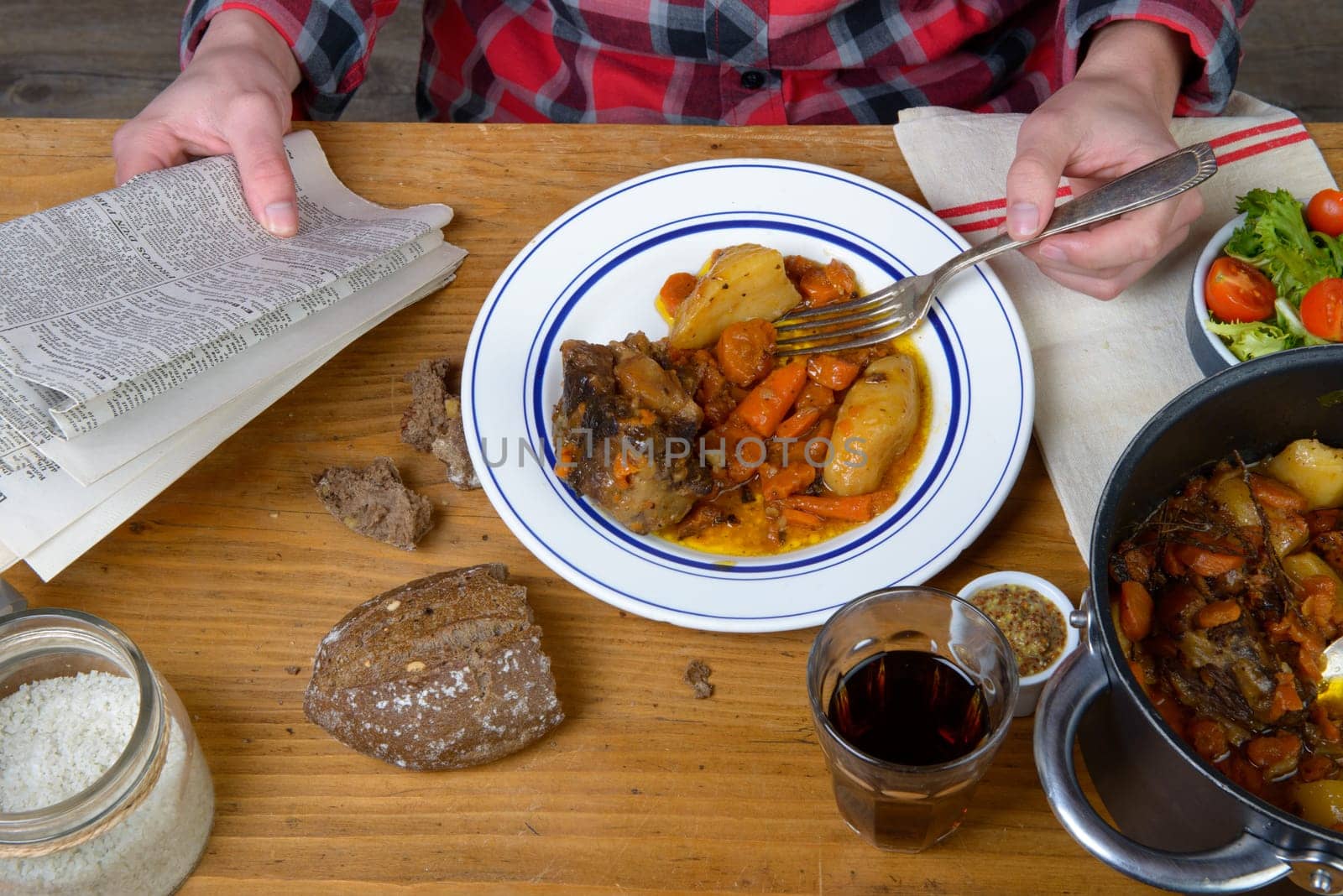 a man eat beef carrot and reading a newspaper