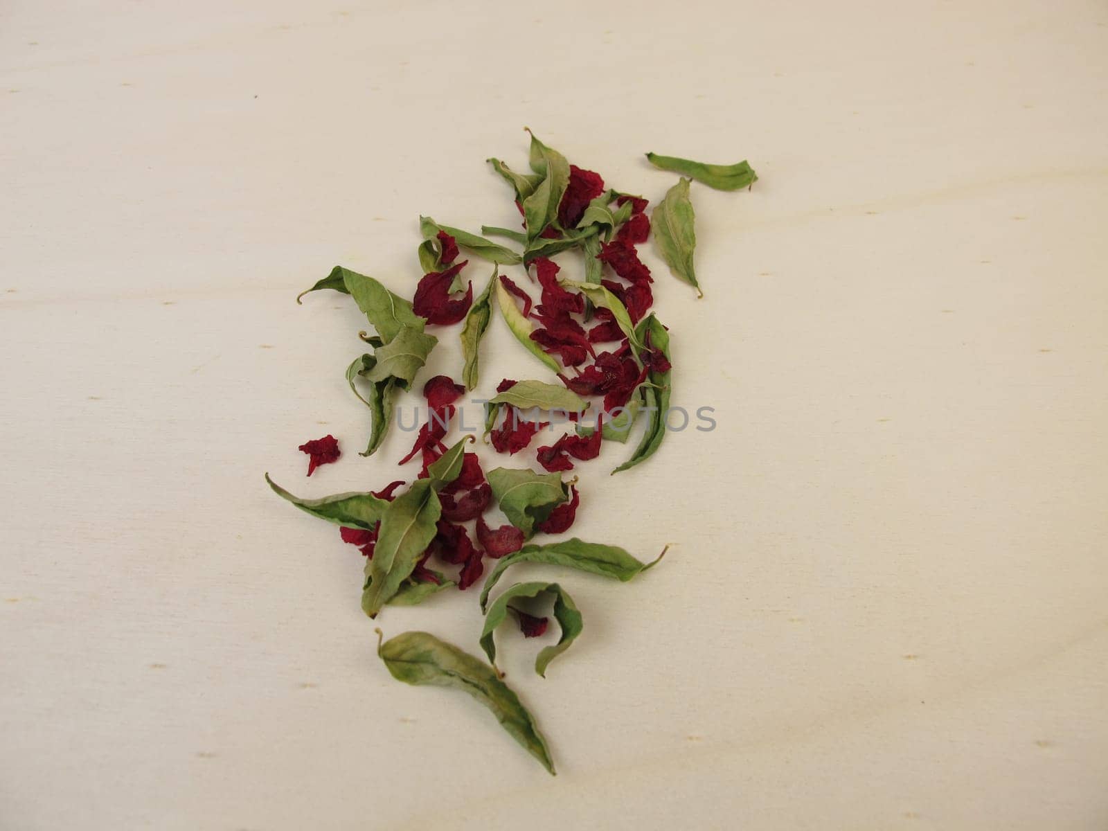 Dried pomegranate leaves and dried pomegranate flowers on a wooden board