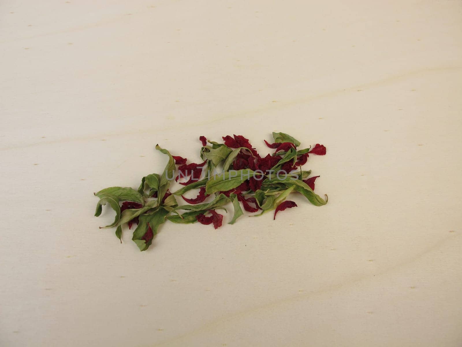 Dried pomegranate leaves and dried pomegranate flowers on a wooden board