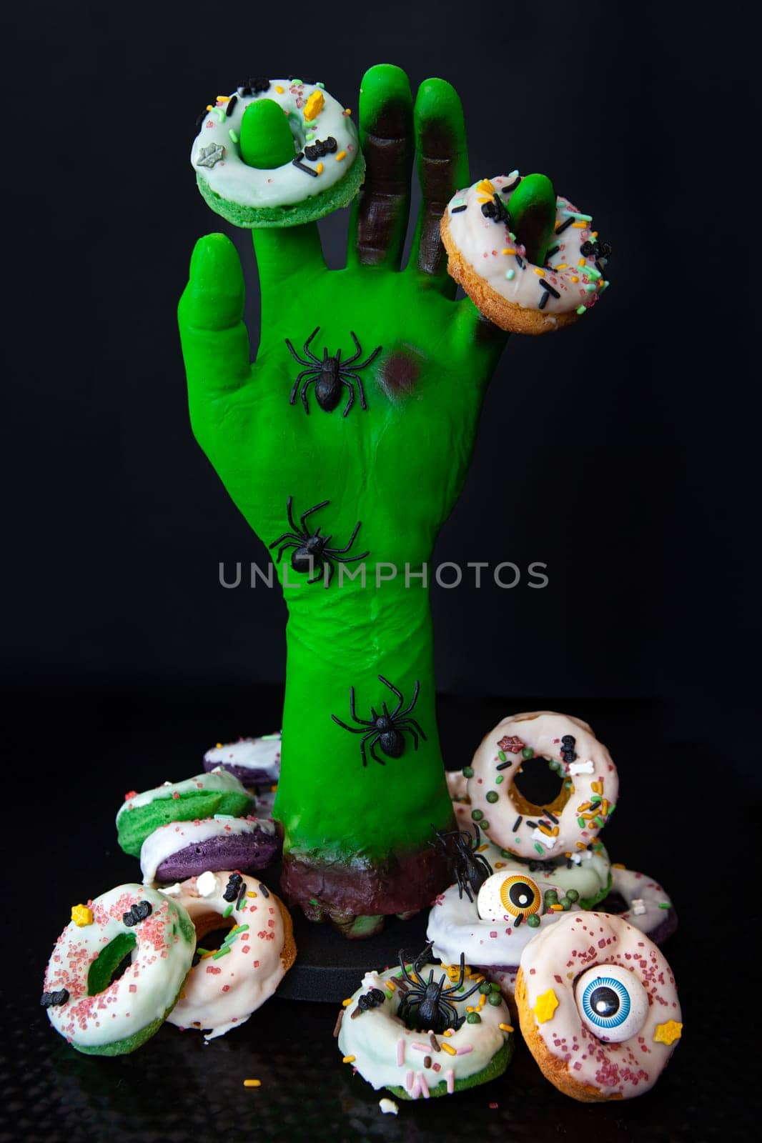 Green zombie hand with homemade sugar frosted donuts