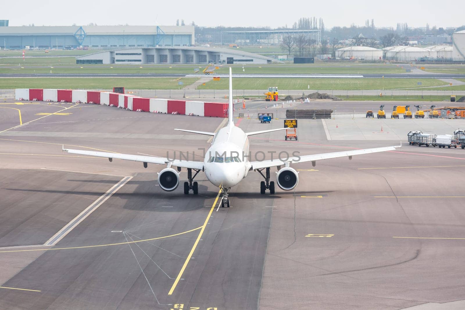 White Airplane waiting on taxiway ready to takeoff