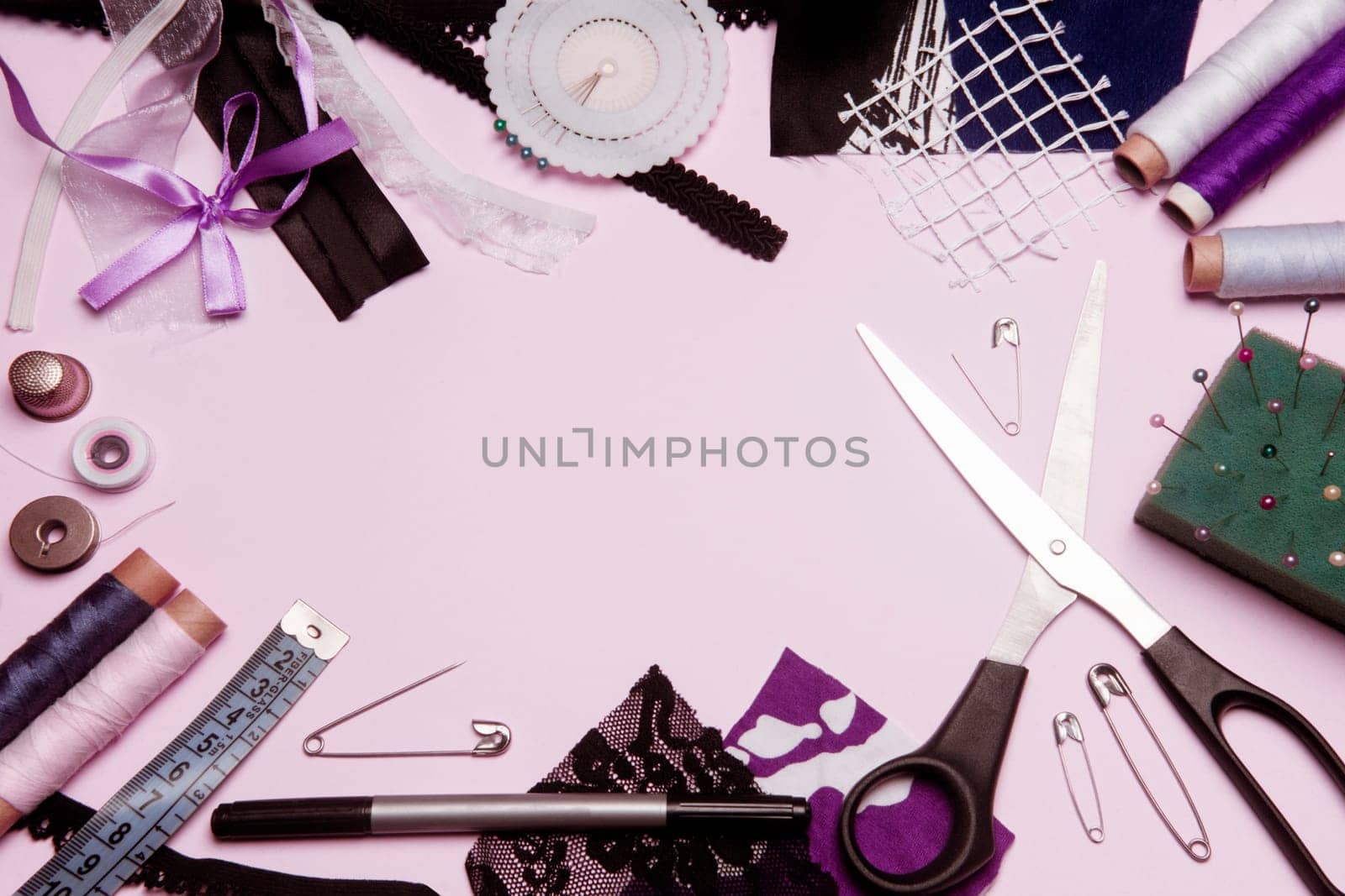 Sewing kit or sewing supplies are on pink background.