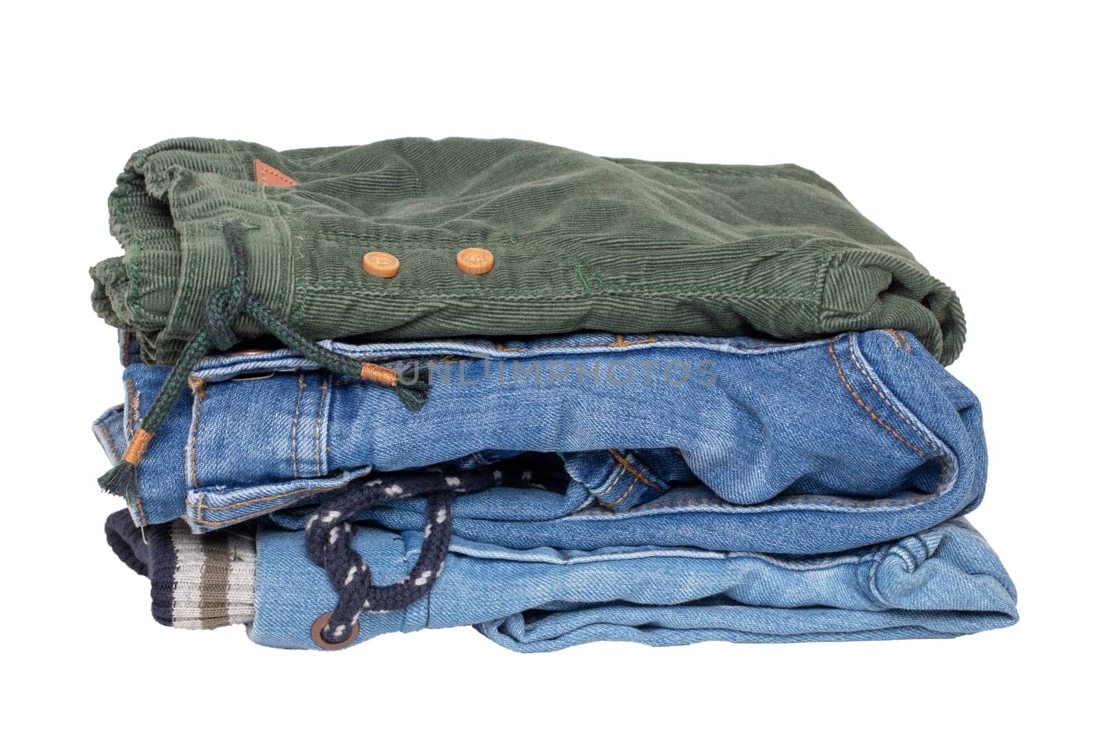 Stack of jeans clothes. Close-up of a stack of jeans for kids isolated on a white background. Denim fashion for children. Macro.