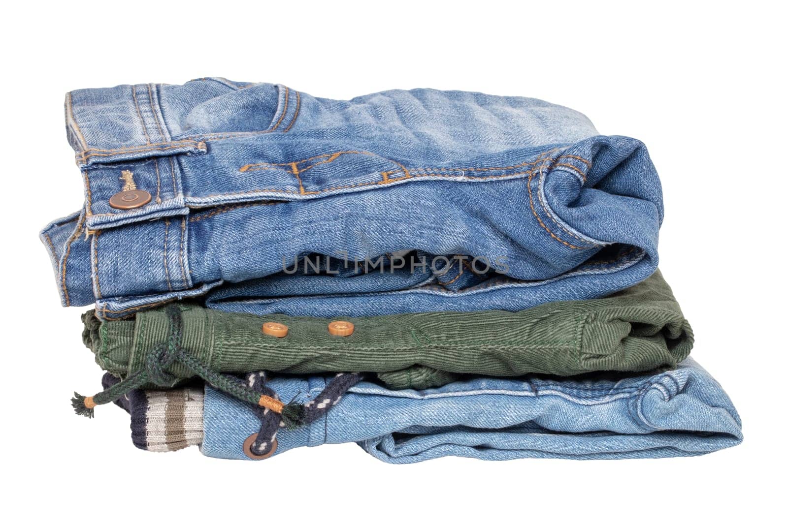 Stack of jeans clothes. Close-up of a stack of jeans for kids isolated on a white background. Denim fashion for children. Macro.