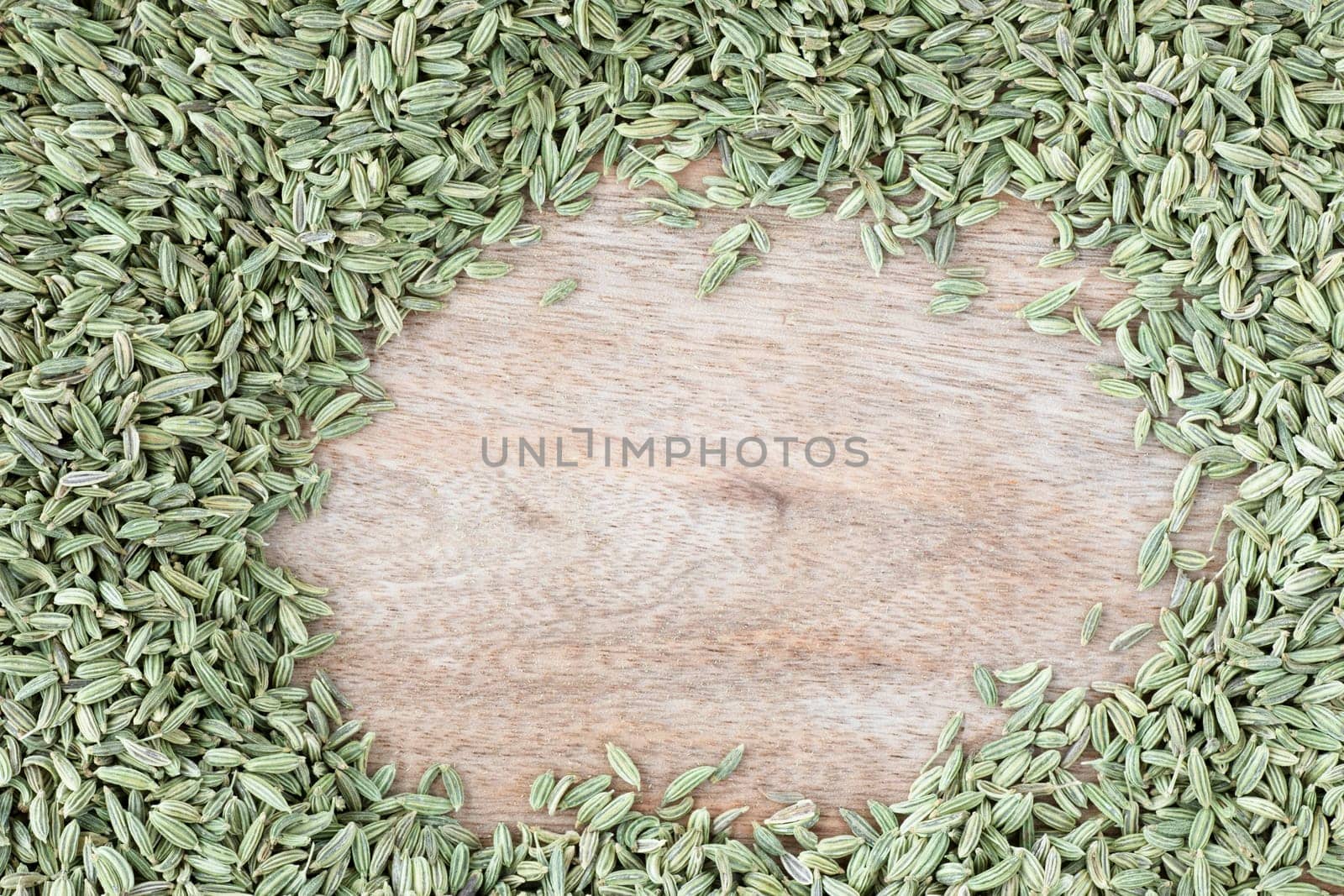 Fennel Seeds on wooden surface with copy space in the middle