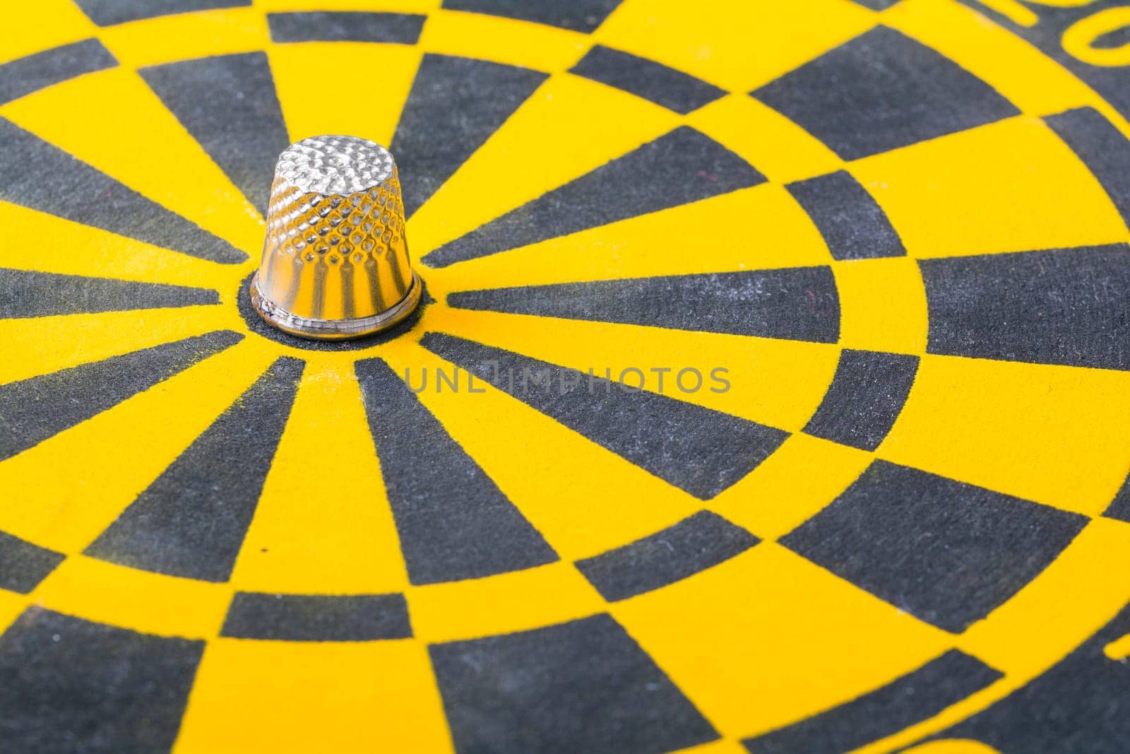 a thimble on an dartboard - symbol foto - closeup
