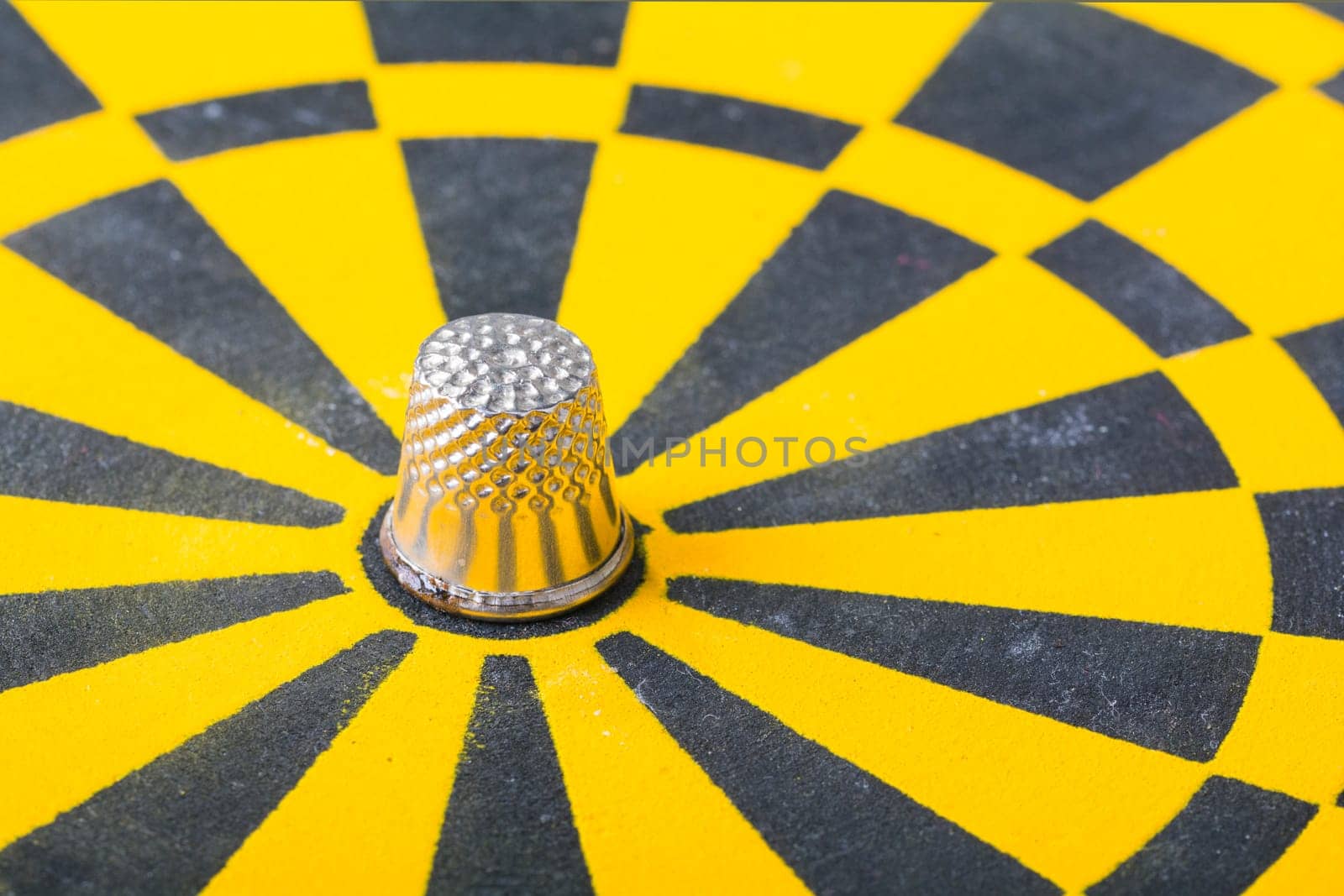 a thimble on an dartboard - symbol foto - closeup