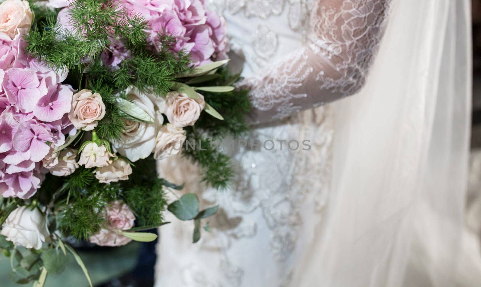 Bride holds big bouquet during ceremony. Couple standing in church for holy matrimony