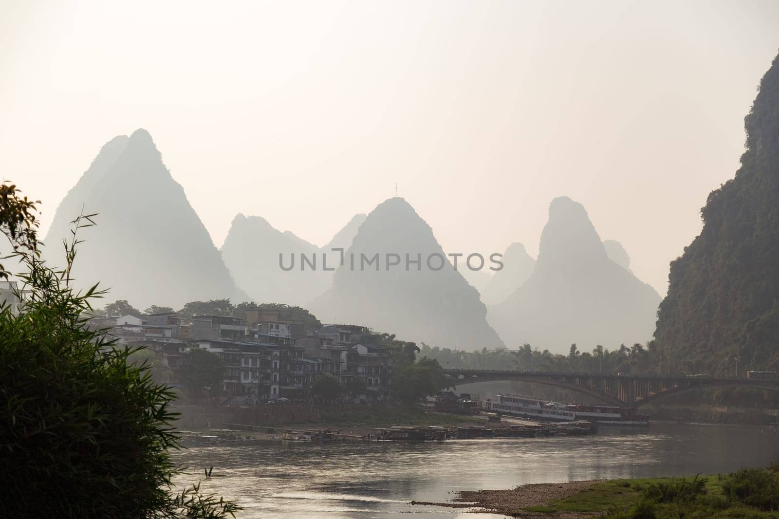 Misty sunrise in the mountains of Asia, a village on the banks of the river, Yangshuo China
