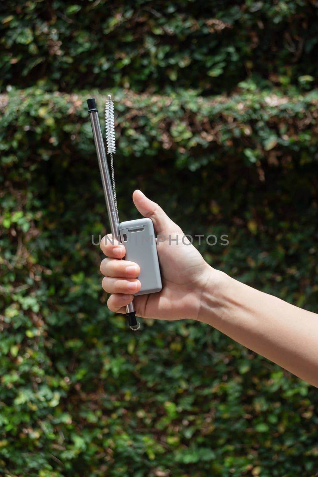 Hand on reusable collapsible drinking straw, stock photo