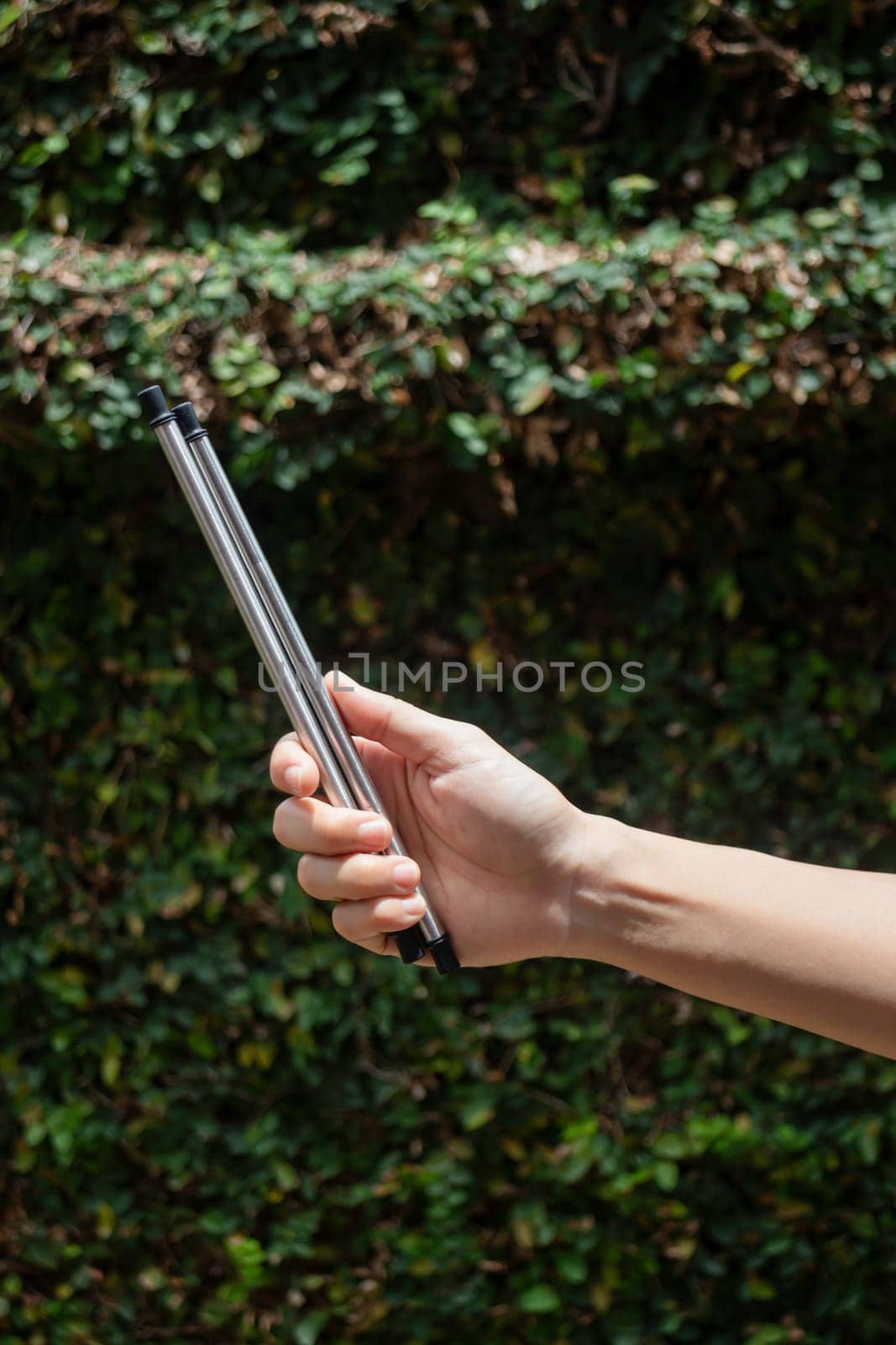 Hand on reusable collapsible drinking straw, stock photo