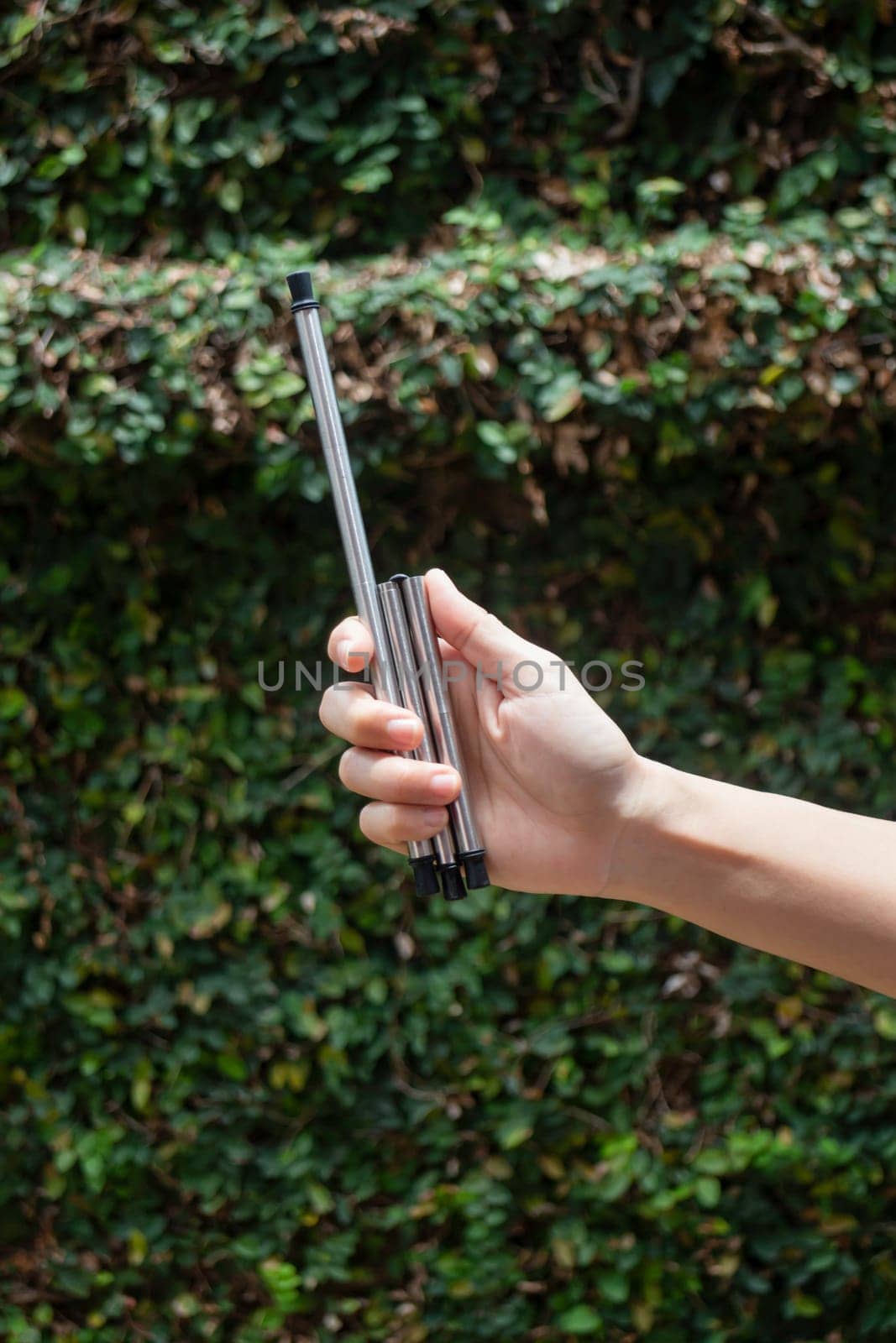 Hand on reusable collapsible drinking straw, stock photo