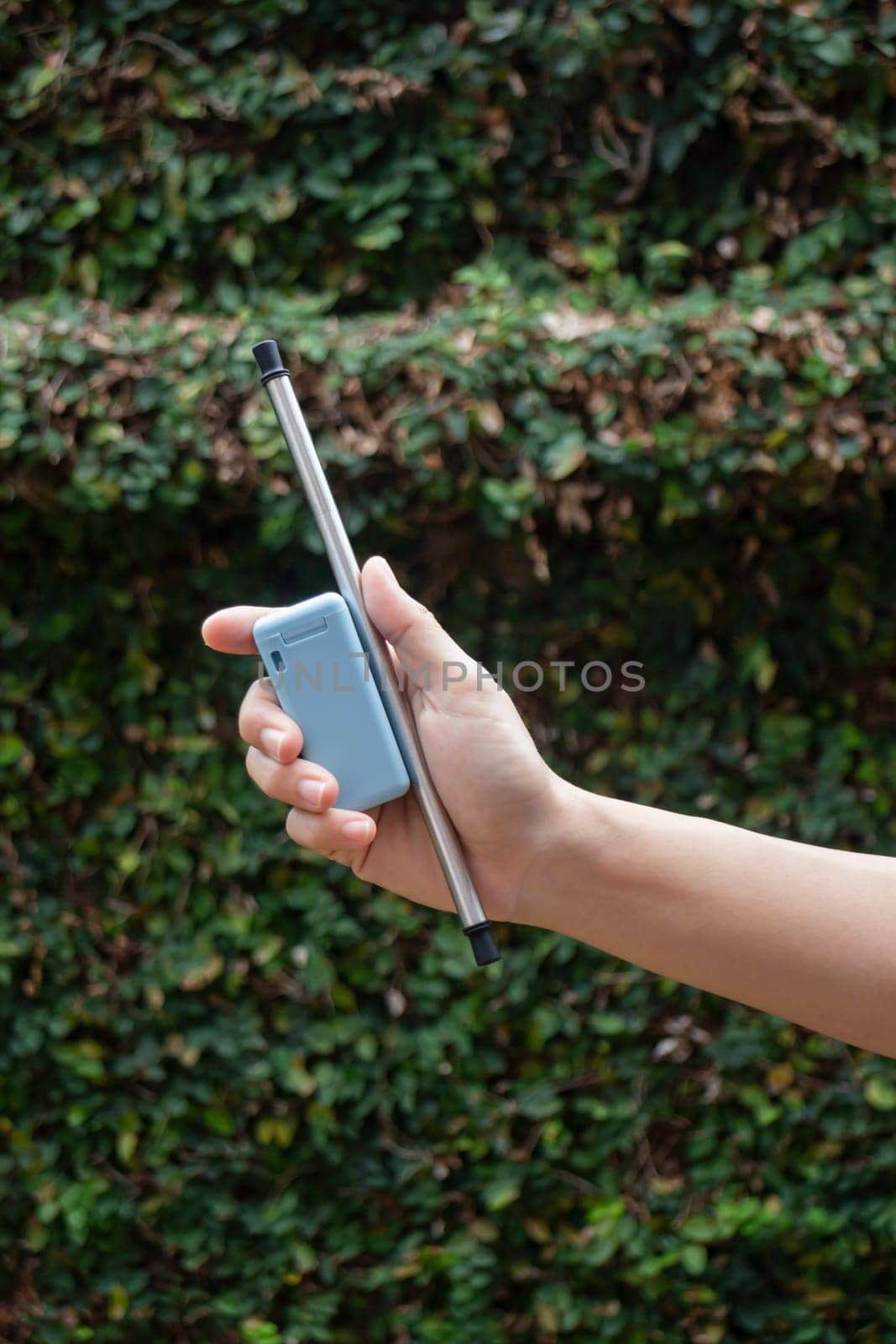 Hand on reusable collapsible drinking straw, stock photo