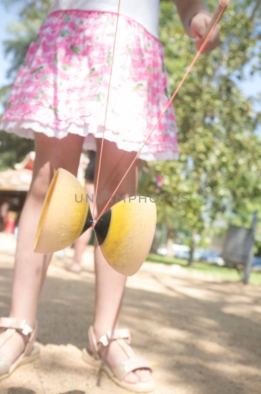 Little girl learning to use diabolo in the park. Classic games for children concept
