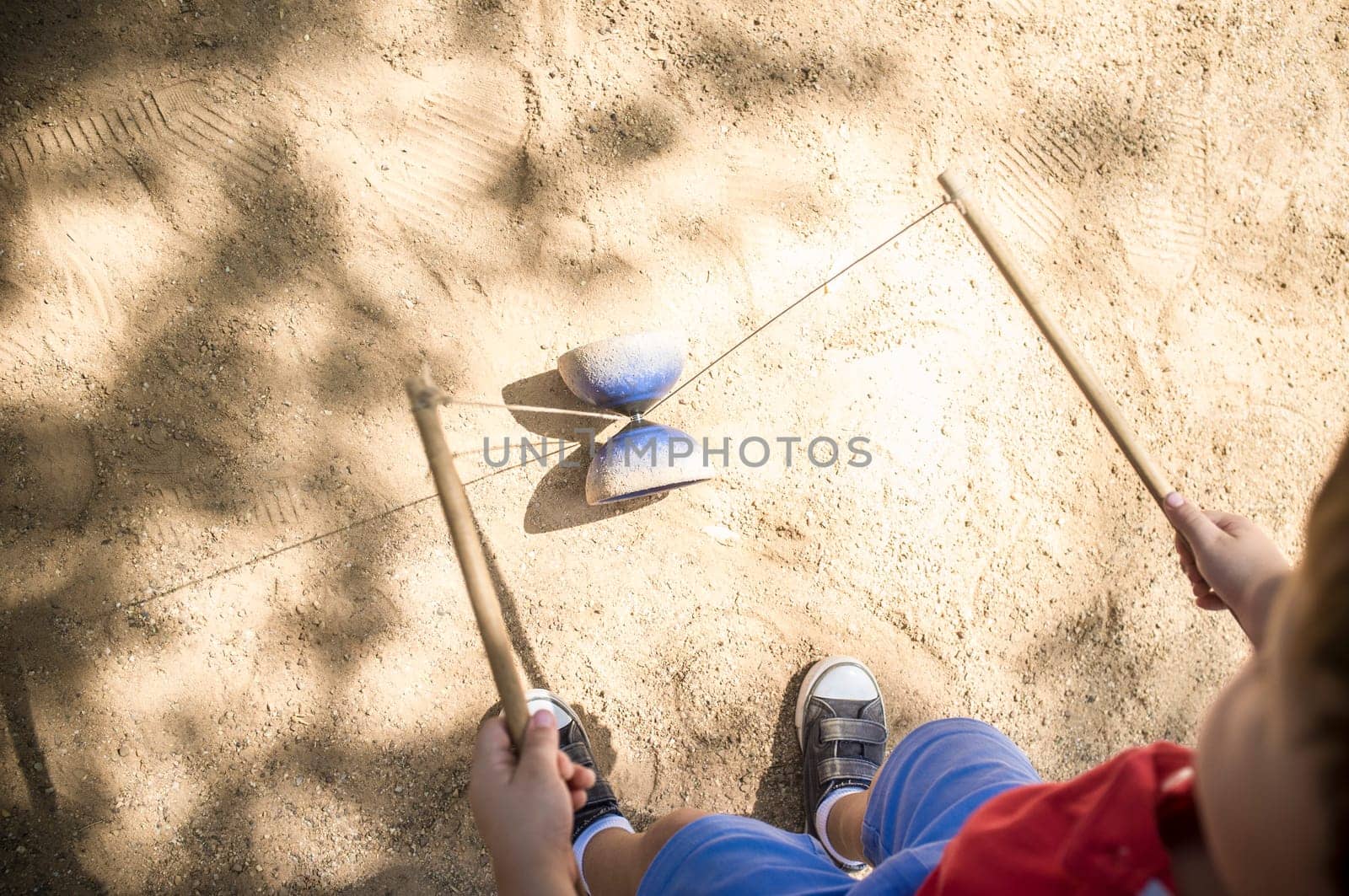 Little boy learning to use diabolo i the park. Classic games for children concept