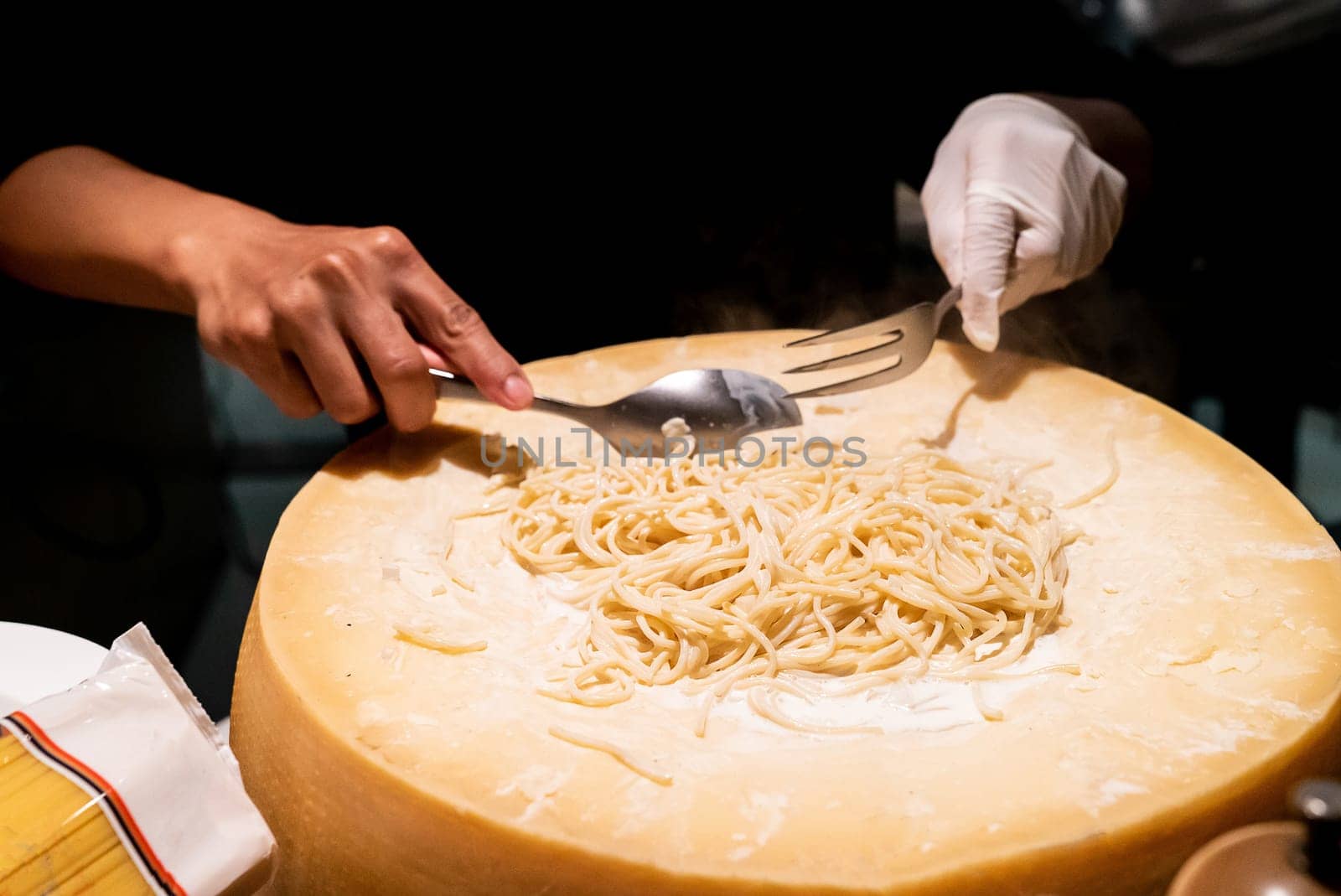 Chef cooking pasta in cheese bowl
