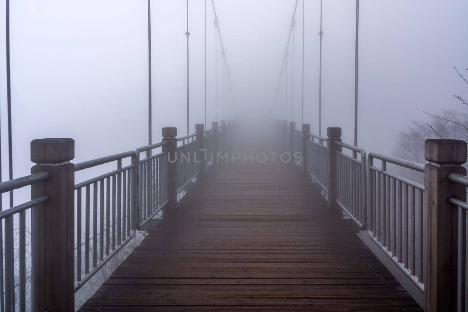 Wooden hanging bridge at Tianmen Mountain vanishing in very heavy mist, fog or inverted cloud Zhangjiajie, Hunan, China. Halloween or horror concept