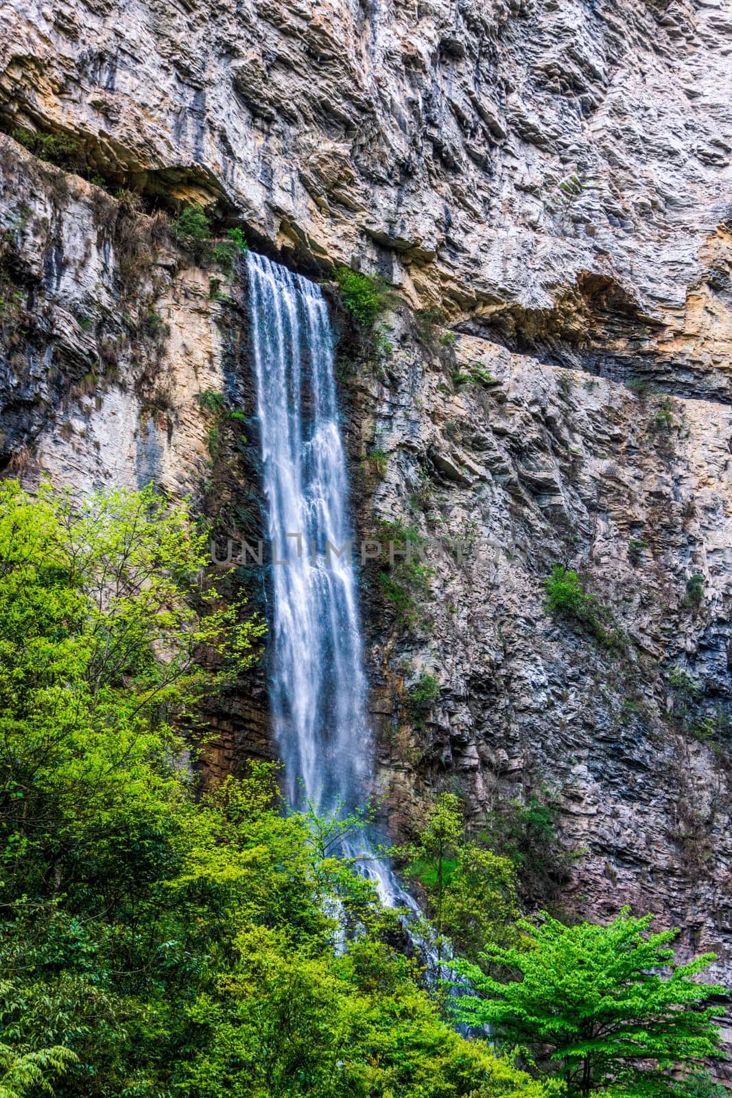 High waterfall falling down from narrow cave in Zhangjiajie in Grand Canyon. Wulingyuan, Hunan, China