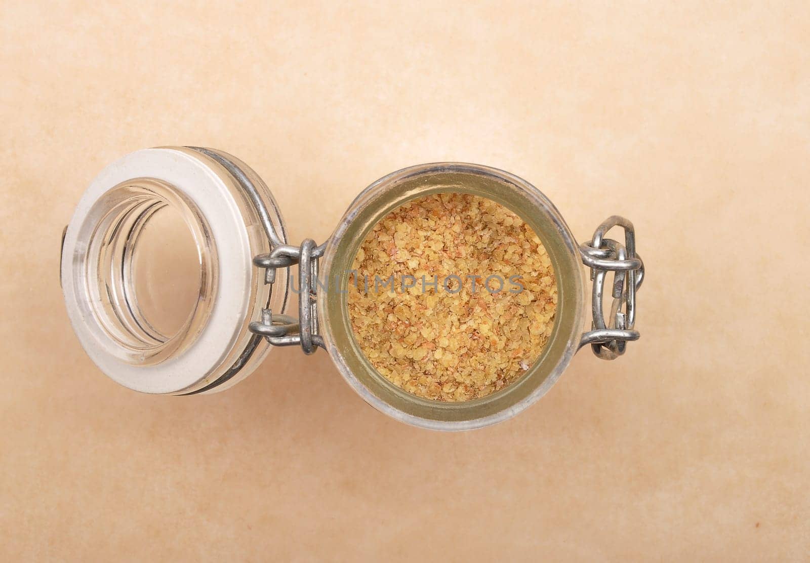 Wheat germs in open jar on brown background