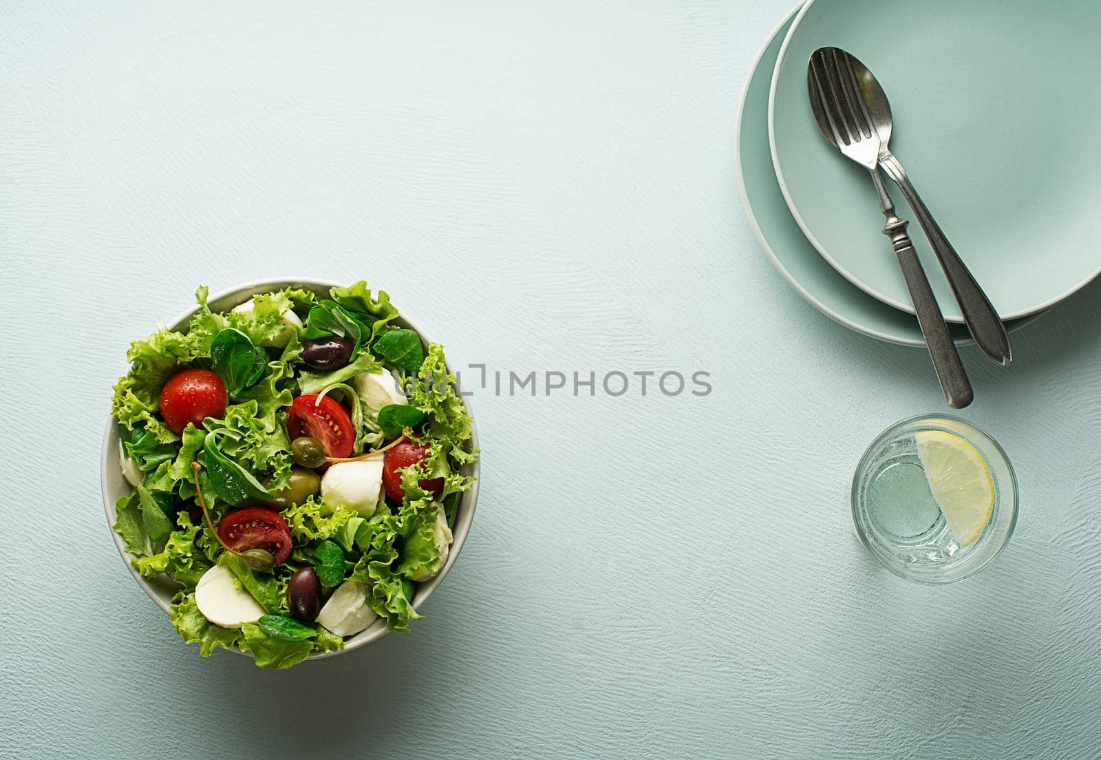Healthy green salad with tomato and mozzarella cheese. Home made food. Concept for a tasty and healthy meal