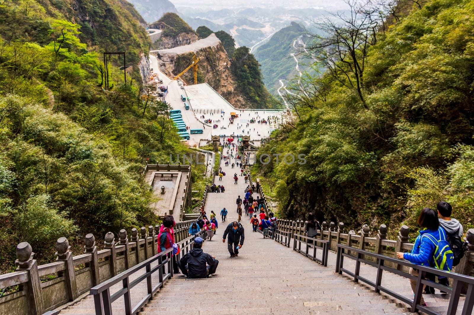 Zhangjiajie, Hunan, China Apr 2013 Tiered tourists climbing 999 stairs to Haven Gate in Tianman Mountains. View from stairs on climbing people below