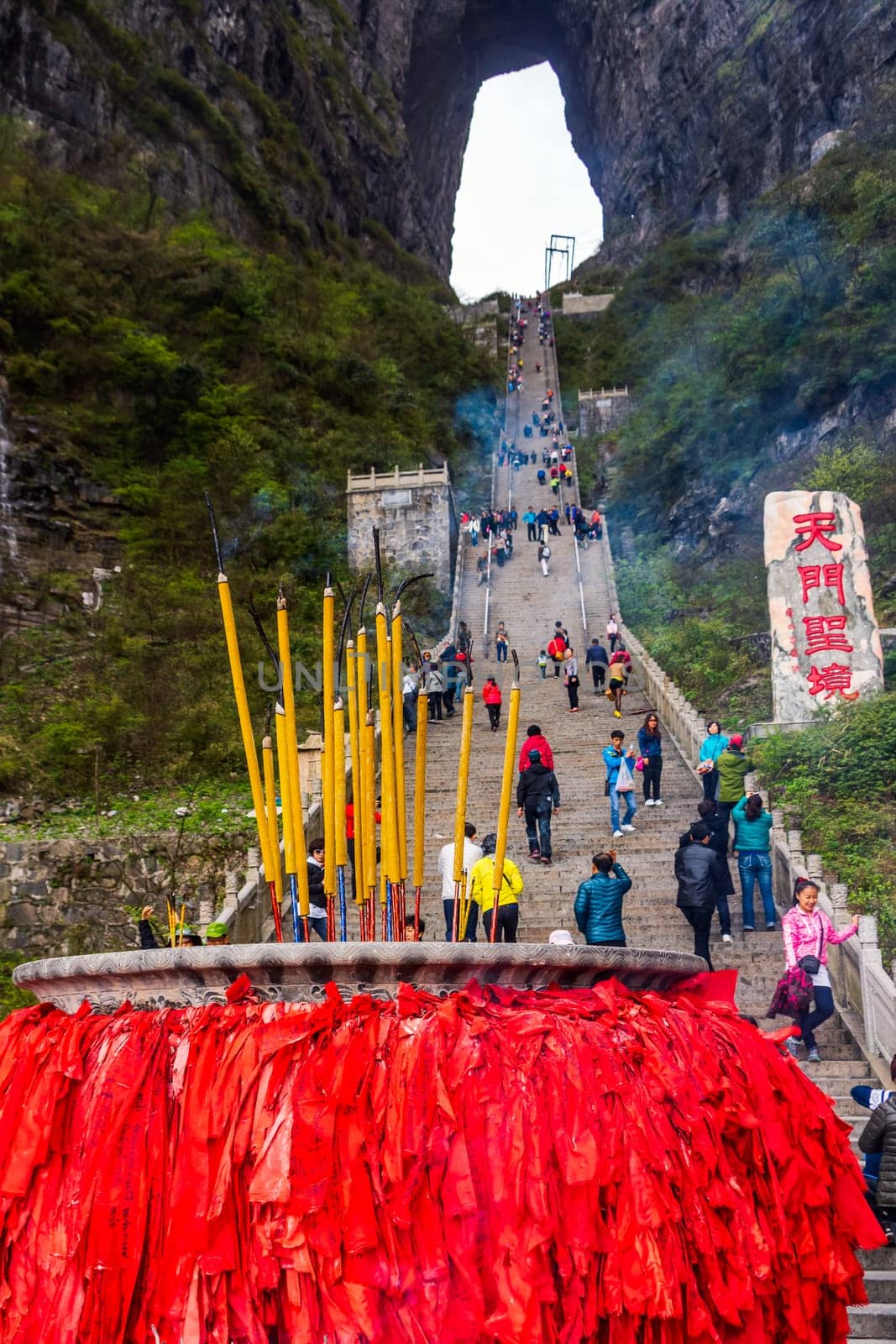 Zhangjiajie, Hunan, China Apr 2013 Incense pot on the bottom platform and tourists climbing 999 stairs to Haven Gate in Tianman Mountains