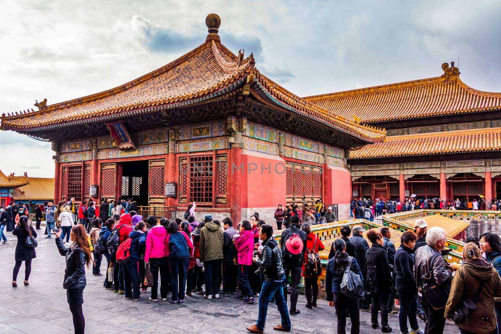 Beijing, China April 2013 Crowd of tourists visiting Forbidden City and taking pictures, front view on temples with golden roofs