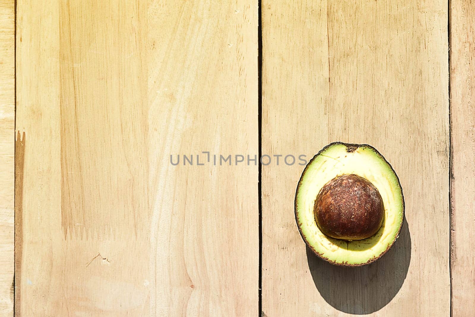 Half avocado on wooden board