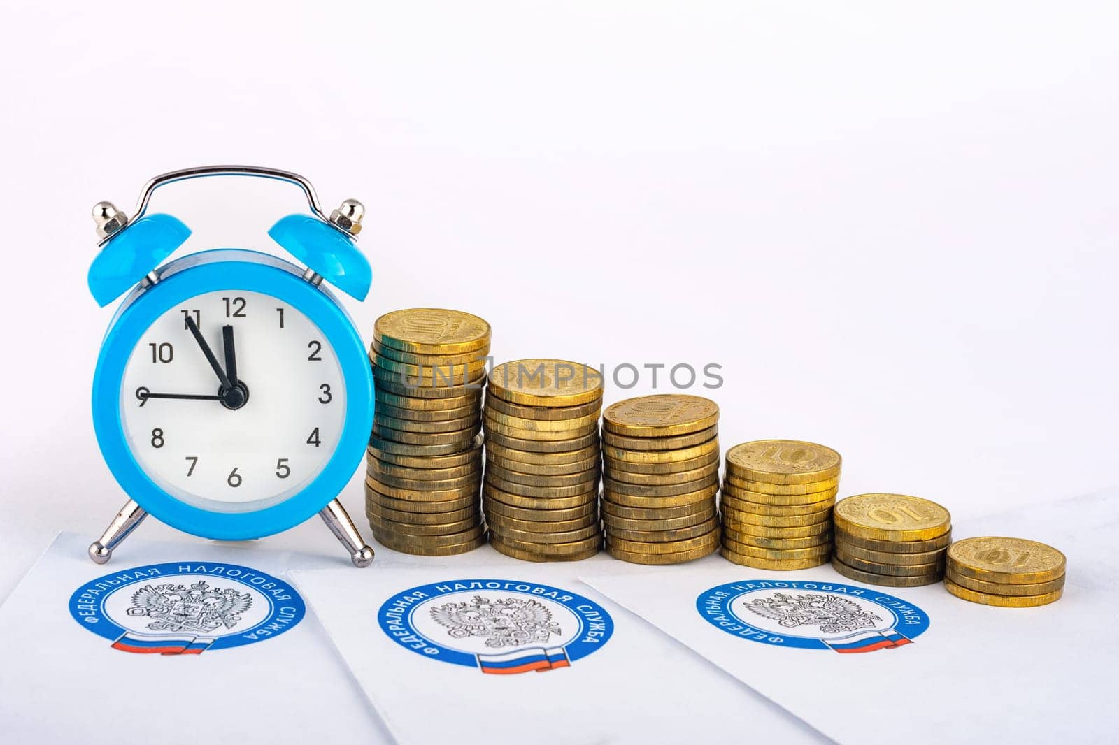 Anapa, Russia - September 3, 2019: Tax notifications, clocks and rising stacks of coins