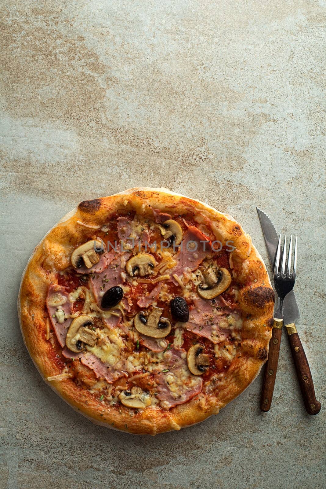 Pizza served with mozzarella cheese, ham, mushrooms and tomato sauce
